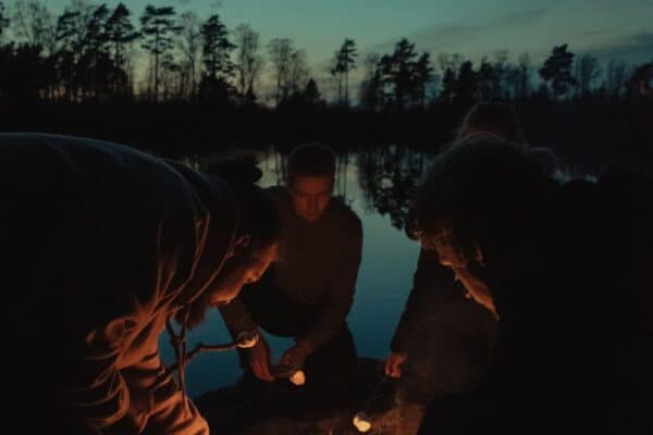 Kaveriporukka nuotion ääressä mökkilomalla